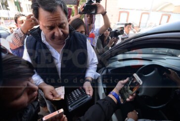 El candidato del PT Oscar González entrega dinero en efectivo a ciudadanos.